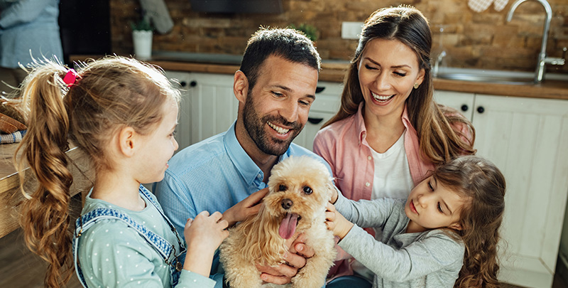 Family with small dog in kitchen satisfied customers of plumbing heating cooling services in des moines