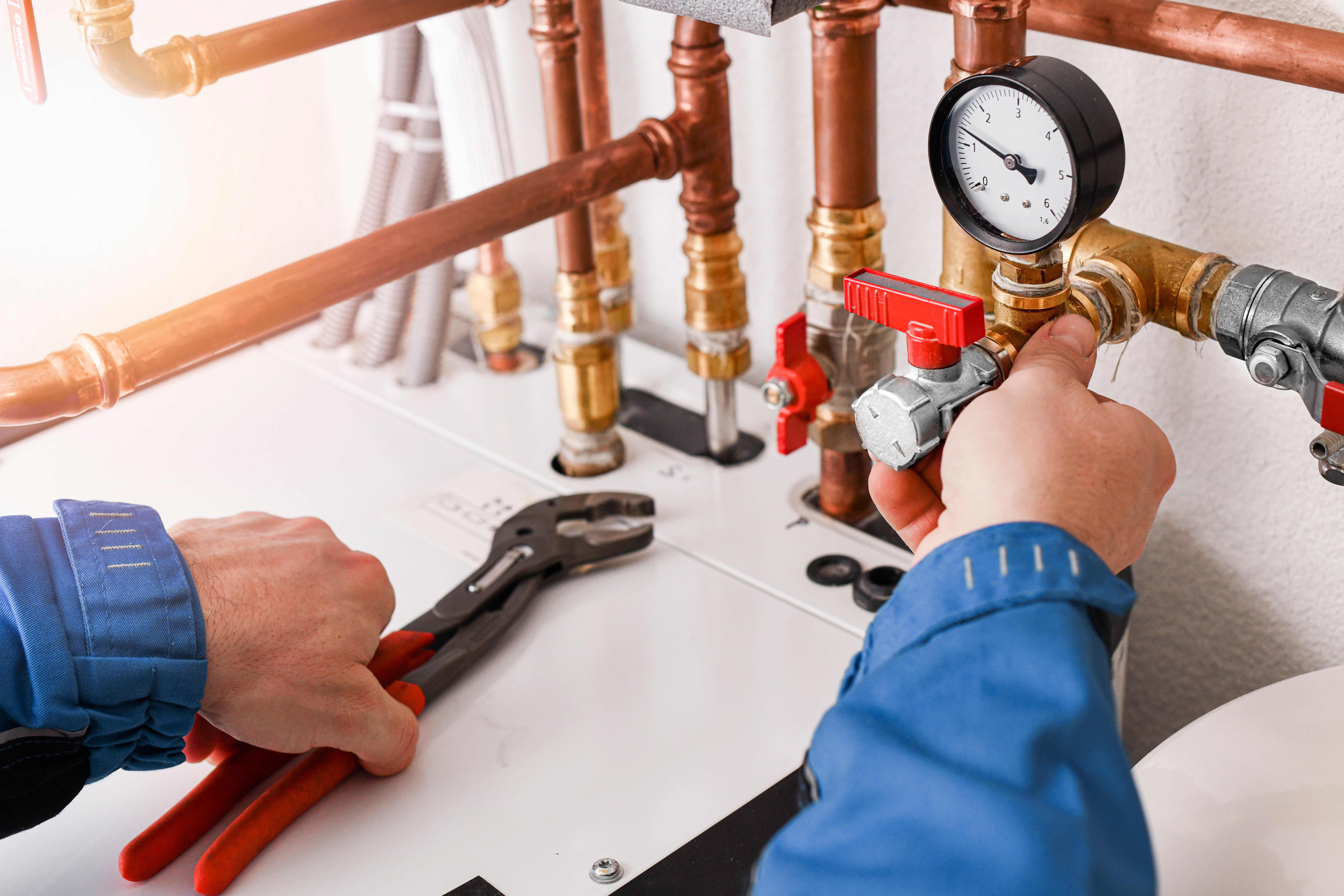 Plumbing concept or service water worker. copper pipeline of a heating system in technical room. Boiler and expansion expansion tank system, detail of pressure gauge.