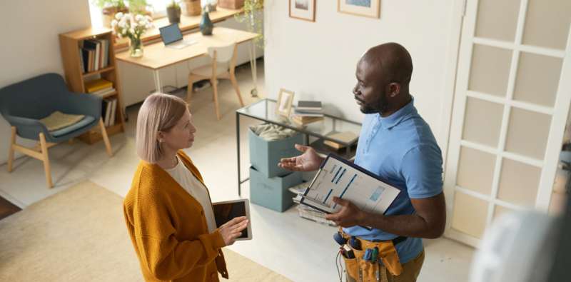 An HVAC inspector explaining their findings to a homeowner
