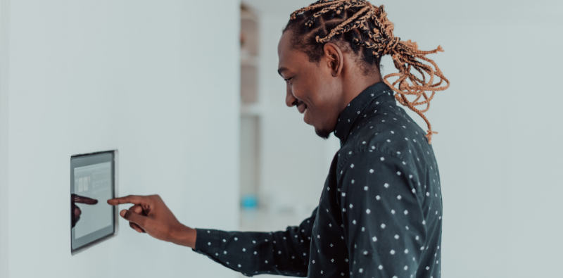 A man making an adjustment to a smart thermostat